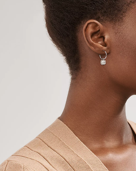 A woman wearing Tiffany & Co. pearl hoop earrings in sterling silver