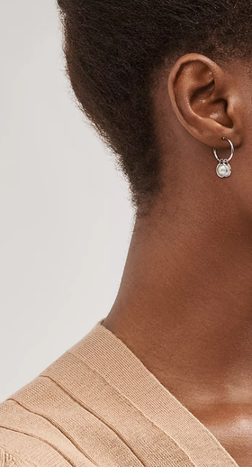 A woman wearing Tiffany & Co. pearl hoop earrings in sterling silver
