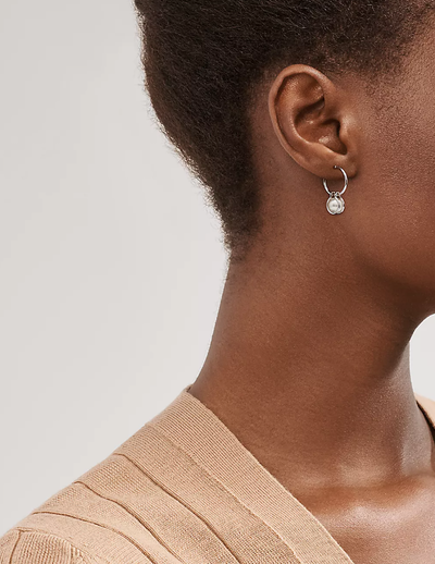 A woman wearing Tiffany & Co. pearl hoop earrings in sterling silver