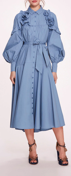 A woman wearing Marchesa Notte denim blue rosette ruffle midi dress