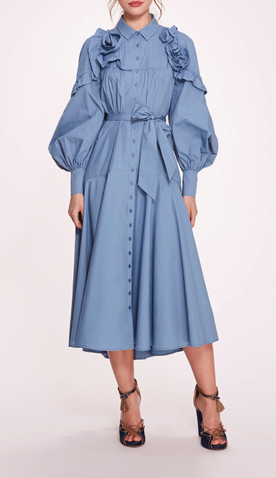 A woman wearing Marchesa Notte denim blue rosette ruffle midi dress