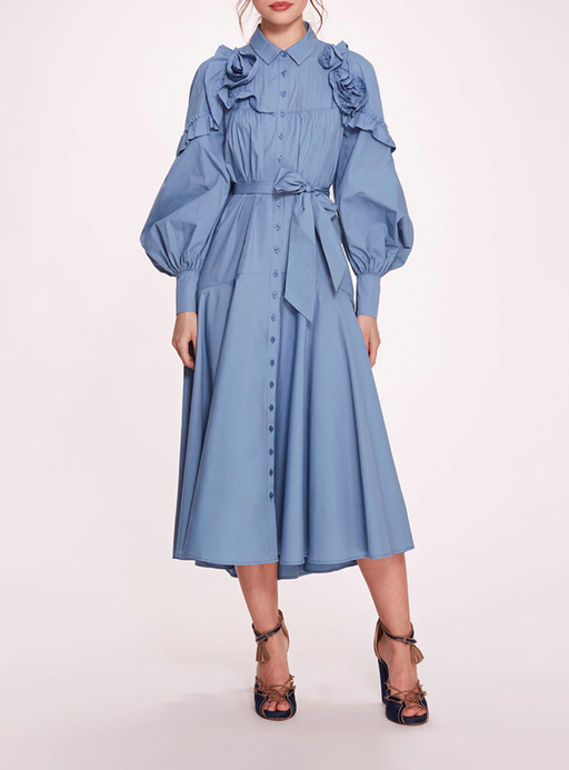 A woman wearing Marchesa Notte denim blue rosette ruffle midi dress