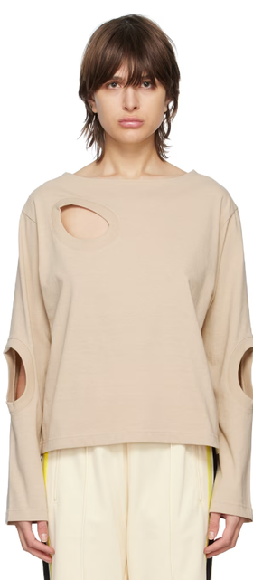 A woman wearing INSCRIRE beige cutouts long sleeve t-shirt