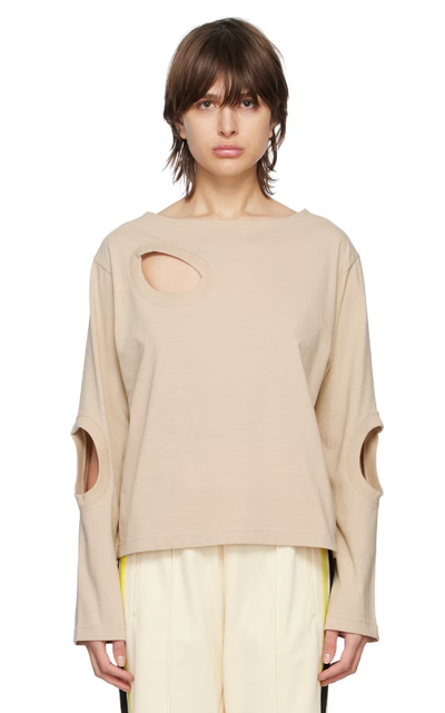 A woman wearing INSCRIRE beige cutouts long sleeve t-shirt