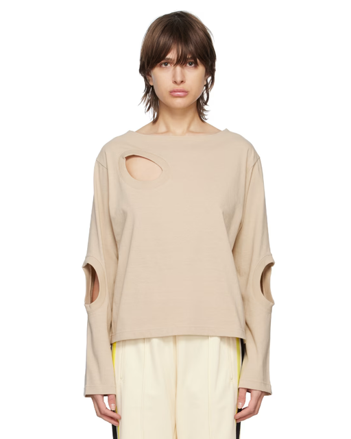 A woman wearing INSCRIRE beige cutouts long sleeve t-shirt