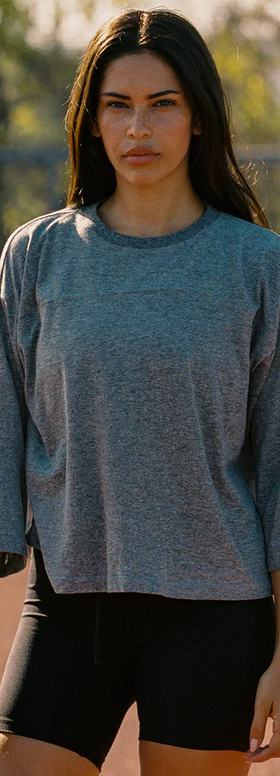 A woman wearing Year of Ours heather grey sunday tee