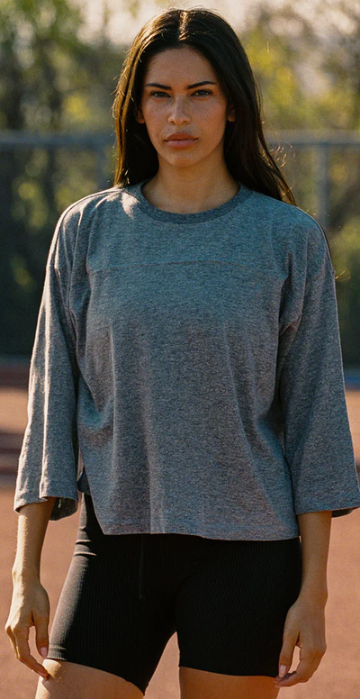 A woman wearing Year of Ours heather grey sunday tee