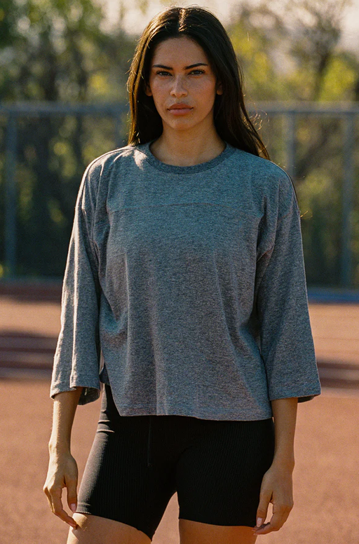A woman wearing Year of Ours heather grey sunday tee