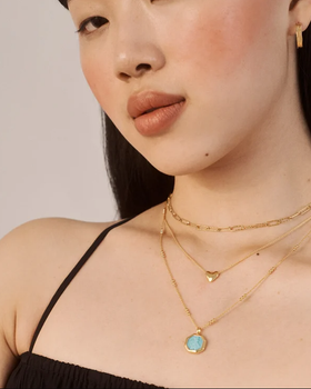 A woman wearing Monica Vinader heart chain necklace