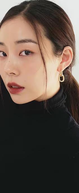 A woman wearing Ana Luisa gold double hoop earrings