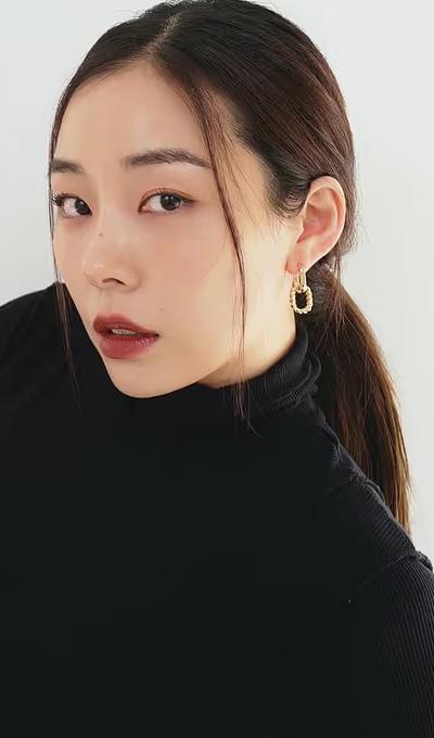 A woman wearing Ana Luisa gold double hoop earrings