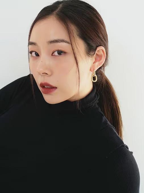 A woman wearing Ana Luisa gold double hoop earrings