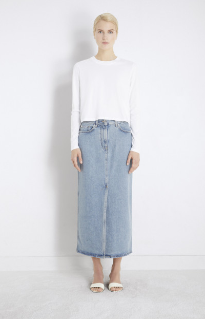 A woman wearing Loulou Studio rona organic denim midi skirt