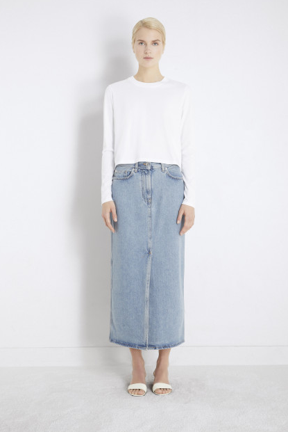 A woman wearing Loulou Studio rona organic denim midi skirt