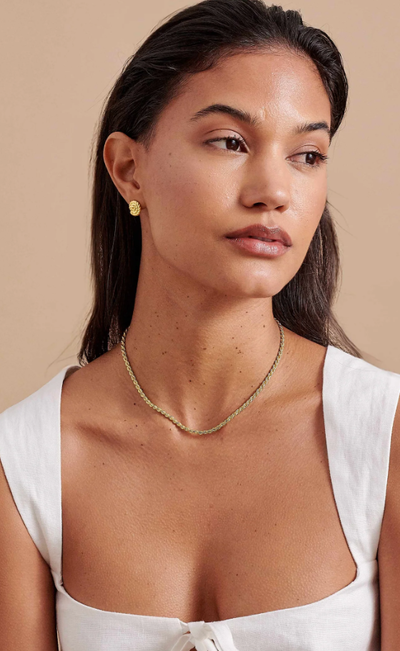 A woman wearing Edge of Ember cove nautical stud earrings