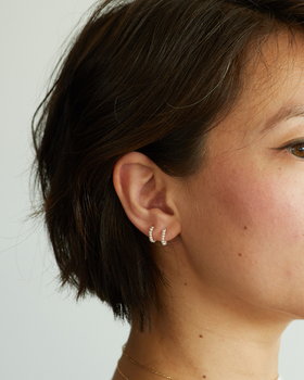 A woman wearing Catbird baby pearl hoop earring (single)