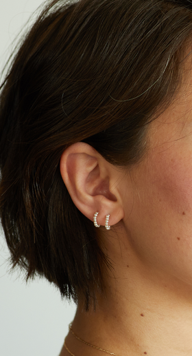 A woman wearing Catbird baby pearl hoop earring (single)