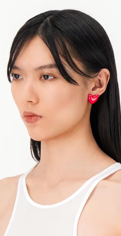 A woman wearing Justine Clenquet devil red earrings