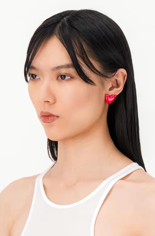 A woman wearing Justine Clenquet devil red earrings