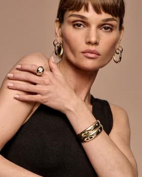 A woman wearing Vrai hoops earrings