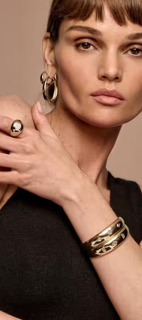 A woman wearing Vrai hoops earrings