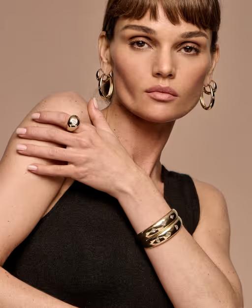 A woman wearing Vrai hoops earrings