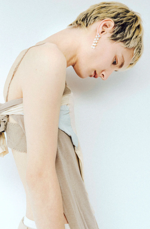 A woman wearing Completedworks pearl and zirconia silver earrings