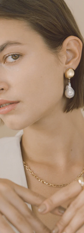 A woman wearing Young Frankk riles baroque pearl earrings