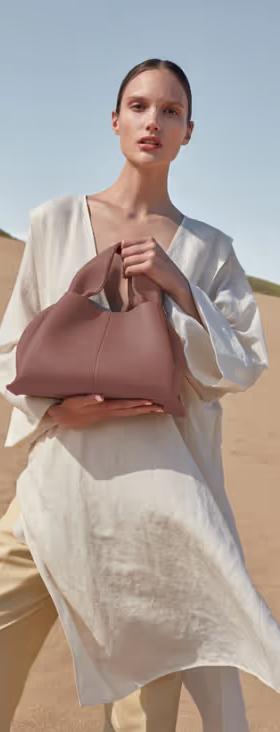 A woman carrying Polene numéro neuf edition blush grainé bag