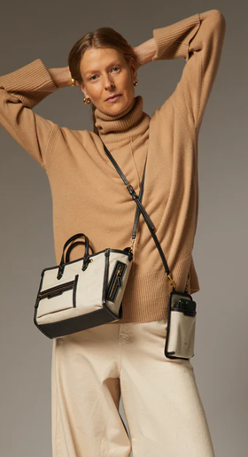 A woman carrying Anya Hindmarch mixed canvas in natural pocket xs cross-body tote bag