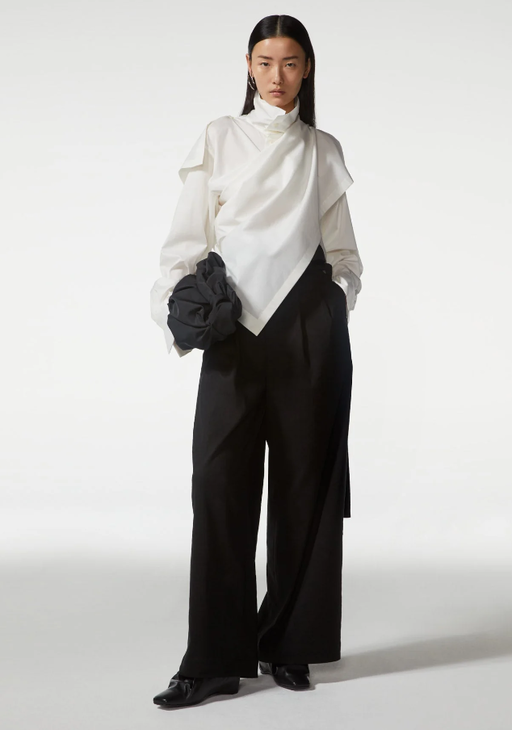 A woman wearing Bao Bao white top and black pant