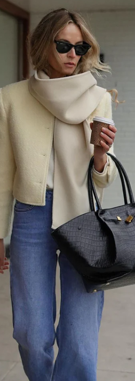 A woman carrying Demellier black small grain bag