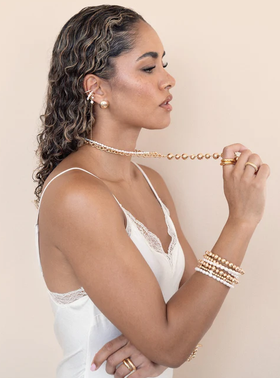 A woman wearing Ettika pearl drama ear cuff set