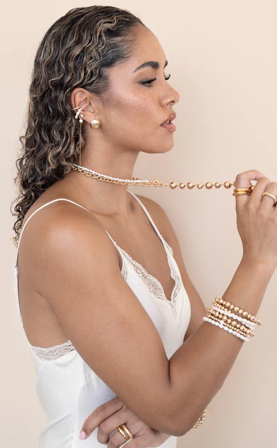A woman wearing Ettika pearl drama ear cuff set
