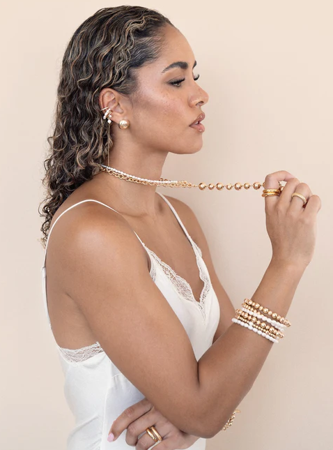 A woman wearing Ettika pearl drama ear cuff set