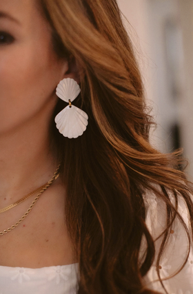 A woman wearing Brinker & Eliza caspia earrings