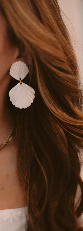 A woman wearing Brinker & Eliza caspia earrings