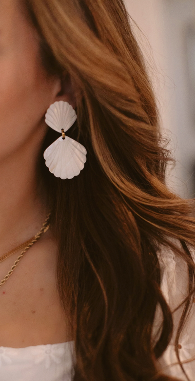 A woman wearing Brinker & Eliza caspia earrings