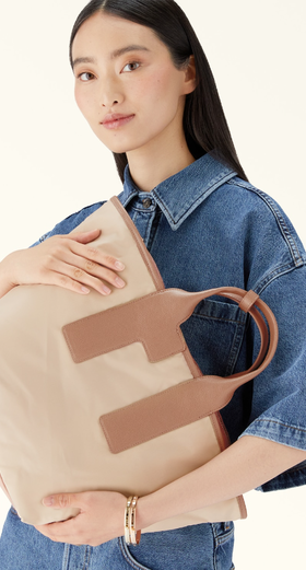 A woman carrying Furla piuma tote bag