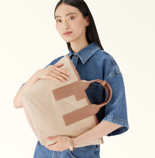 A woman carrying Furla piuma tote bag
