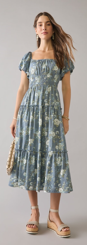 A woman wearing Francesca’s navy sharon tiered floral puff sleeve midi dress
