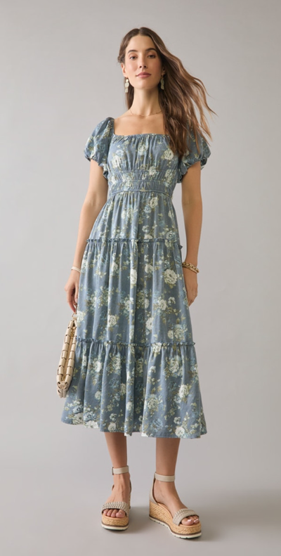 A woman wearing Francesca’s navy sharon tiered floral puff sleeve midi dress