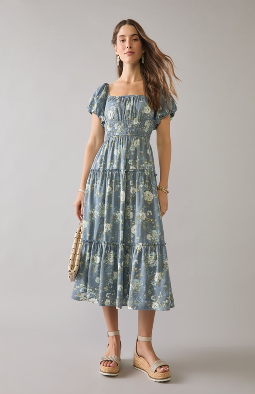 A woman wearing Francesca’s navy sharon tiered floral puff sleeve midi dress