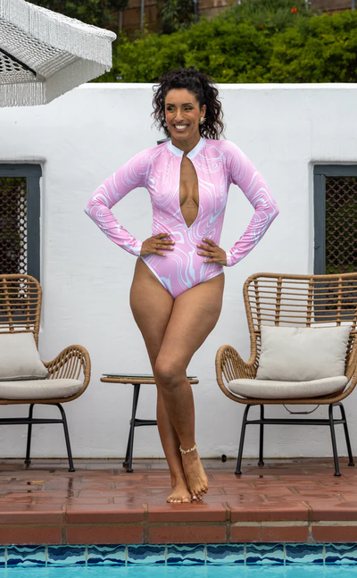 A woman wearing BOLD Swim bubble gum marble color body suit