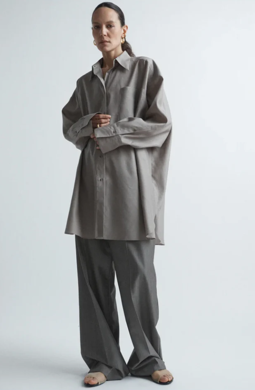 A woman wearing Raey oversized silk and wool shirt