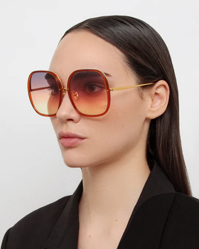 A woman wearing Linda Farrow celia oversized sunglasses in orange