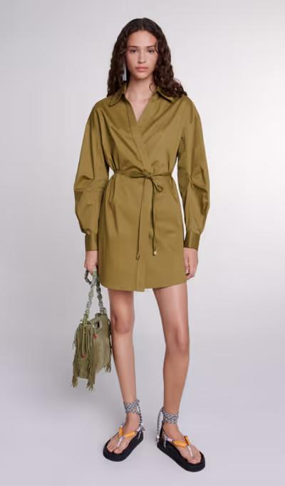 A woman wearing Maje khaki cutaway wrap dress