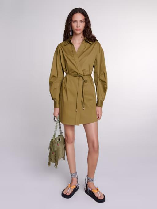 A woman wearing Maje khaki cutaway wrap dress