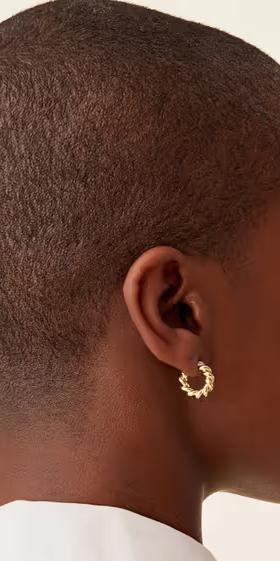 A woman wearing PAVOI rope hoops earrings