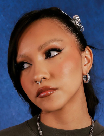 A woman wearing Hard Jewelry astrology hoop earring